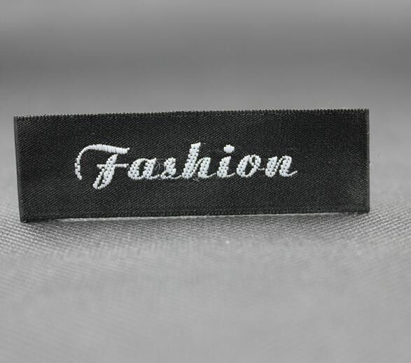 La tela tejida de alta densidad etiqueta el logotipo de la marca del doblez de centro las etiquetas de encargo del cuello